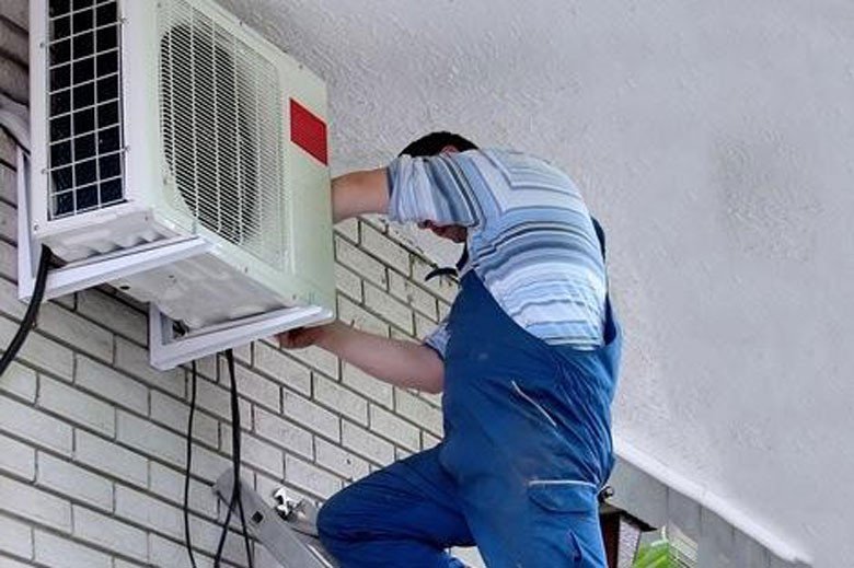 Kỹ thuật viên đang kiểm tra hệ thống dây điện và linh kiện dàn nóng điều hòa Daikin để khắc phục lỗi E0
