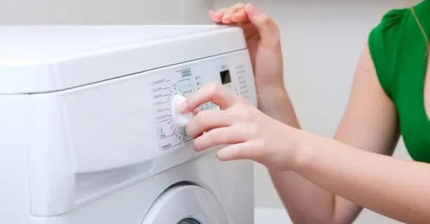 Hình ảnh một người đang lau chùi bên trong ngăn chứa bột giặt của máy giặt