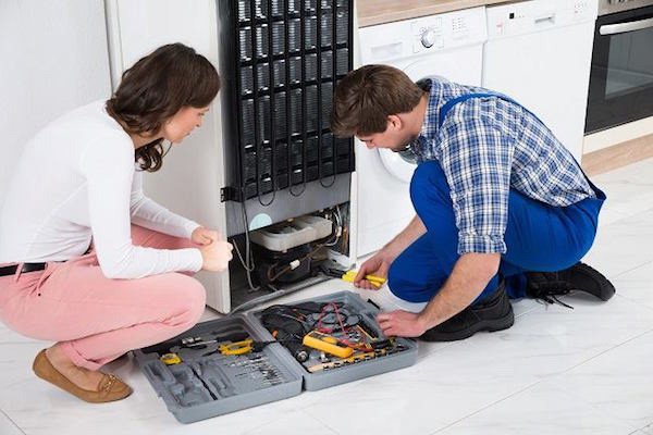 Kỹ thuật viên điện lạnh đang kiểm tra và sửa chữa tủ lạnh tại nhà khách hàng ở Quận 12