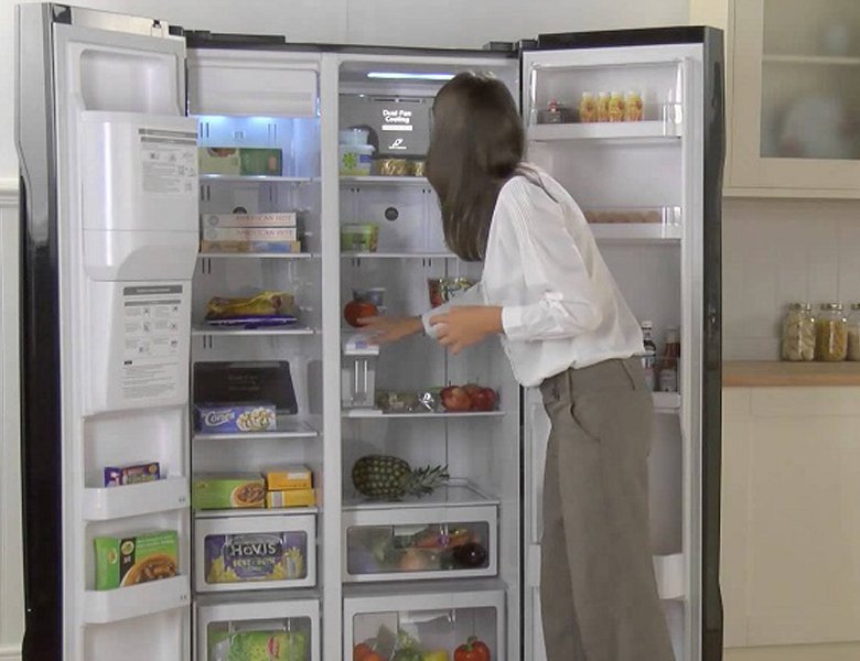 Một bàn tay đang đóng cửa tủ lạnh, nhấn mạnh tầm quan trọng của việc giữ nhiệt độ ổn định.