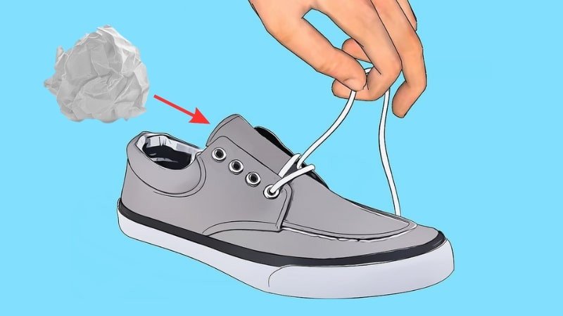 Tháo dây và nhồi giấy hút ẩm vào giày